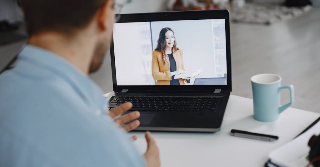 A man participating in a video conference call with a colleague on a laptop at home.