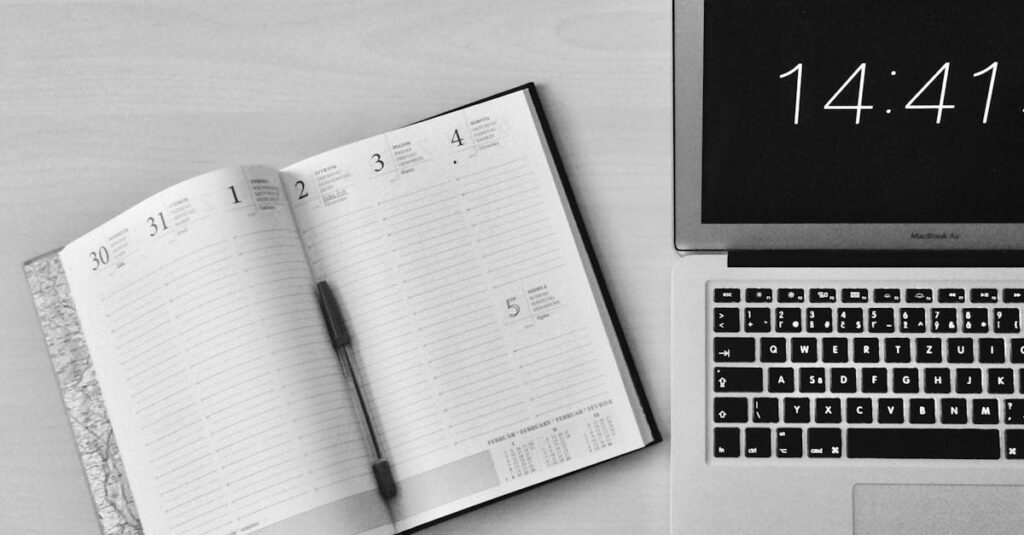 Minimalist office workspace with a notebook and MacBook Air showing 14:41 time.